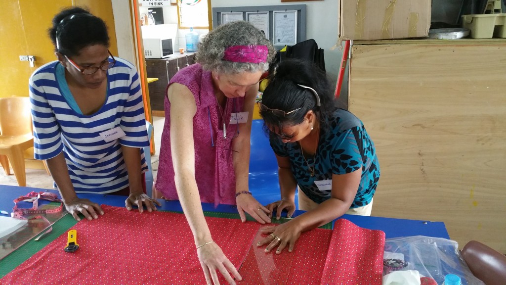 Julie showing the ladies how to cut out their Days For Girls Bag