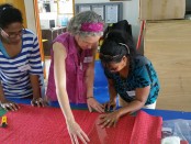 Julie showing the ladies how to cut out their Days For Girls Bag