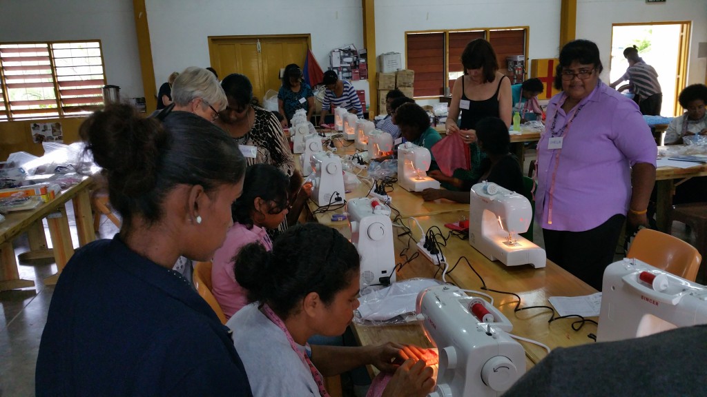 Julie showing the ladies how to cut out their Days For Girls Bag